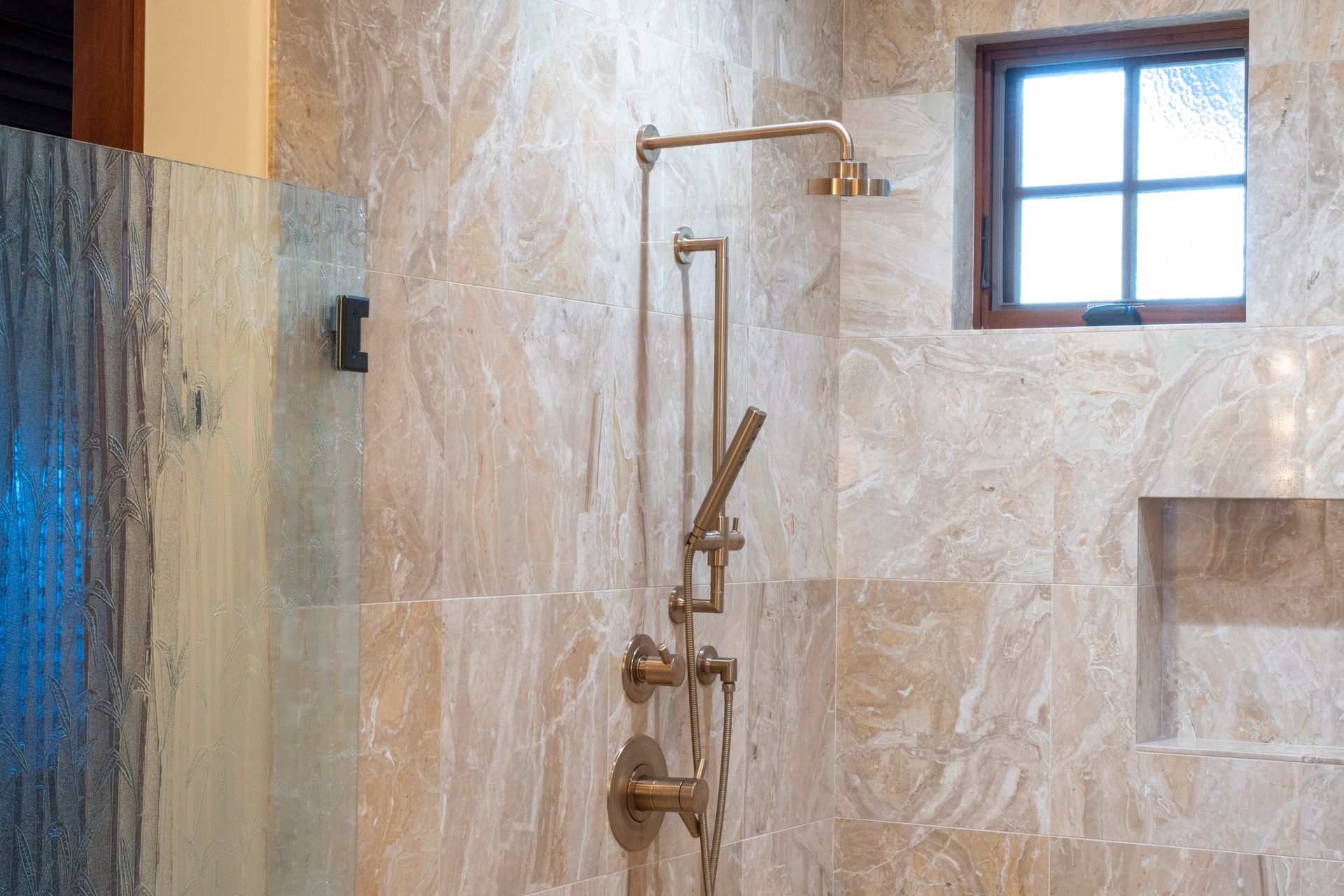 A bathroom with a walk in shower and a window.