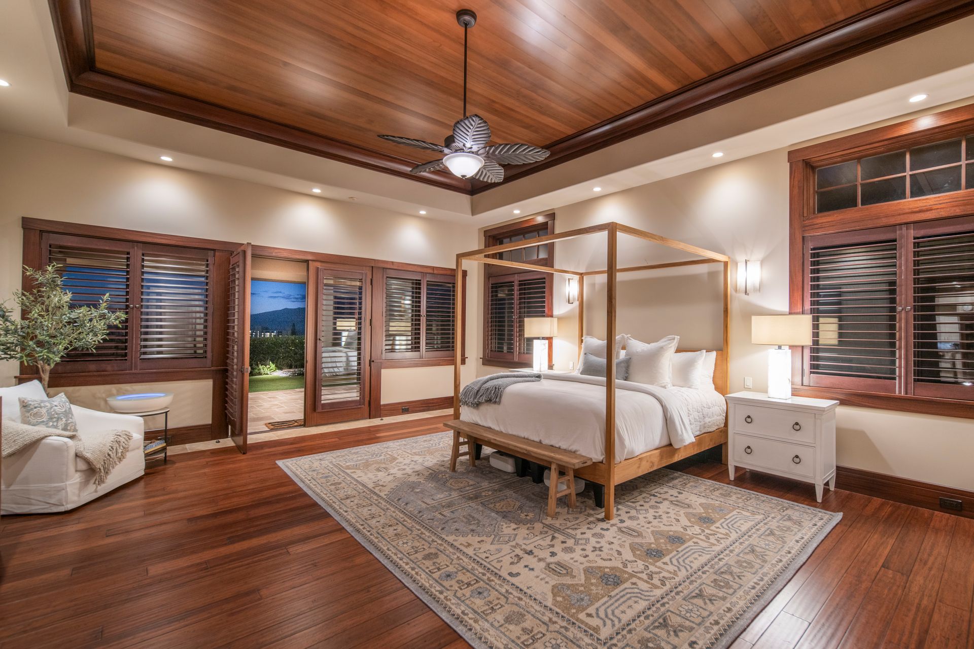 A bedroom with a four poster bed and a ceiling fan.
