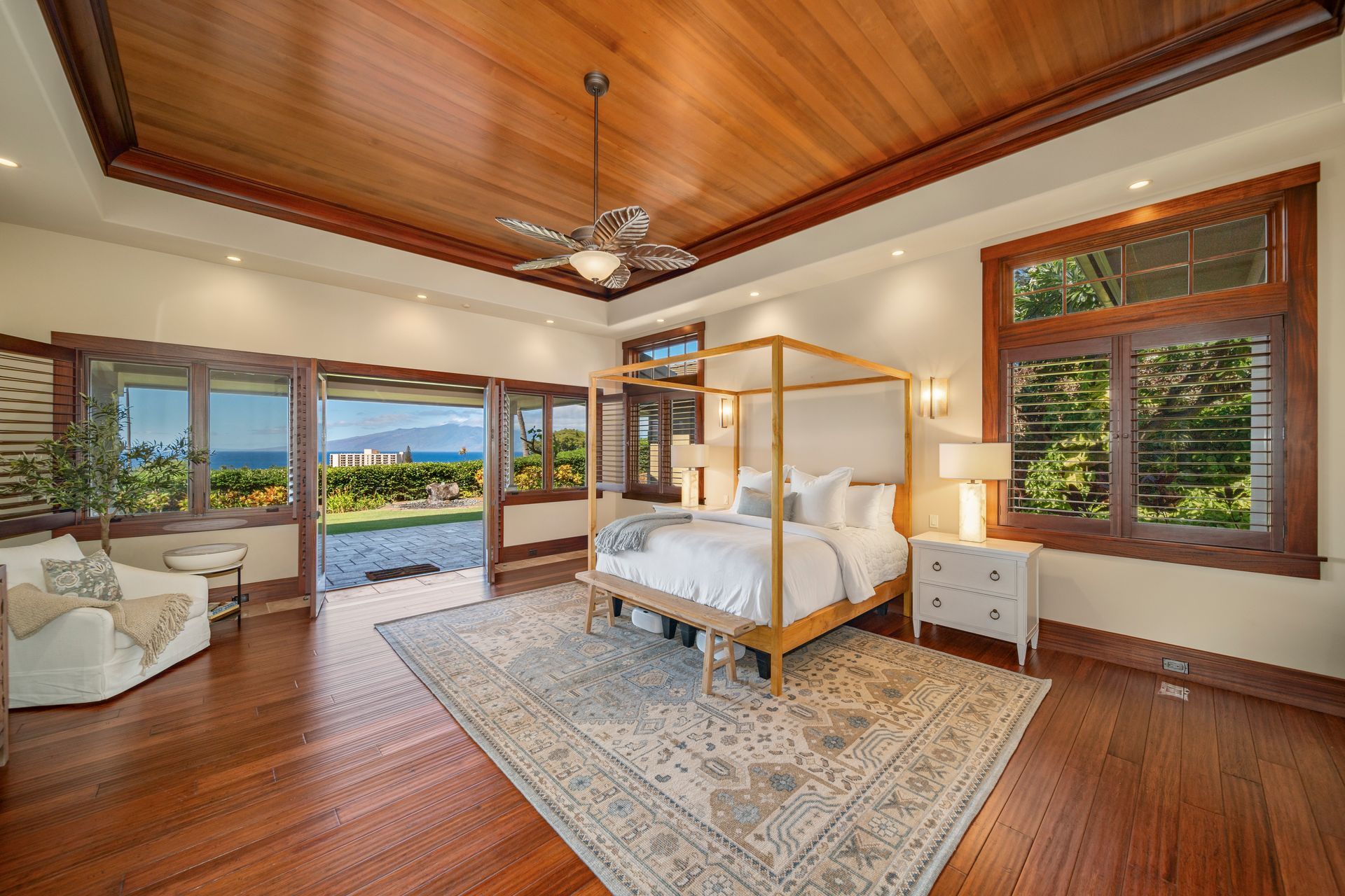 A large bedroom with a canopy bed and a ceiling fan.