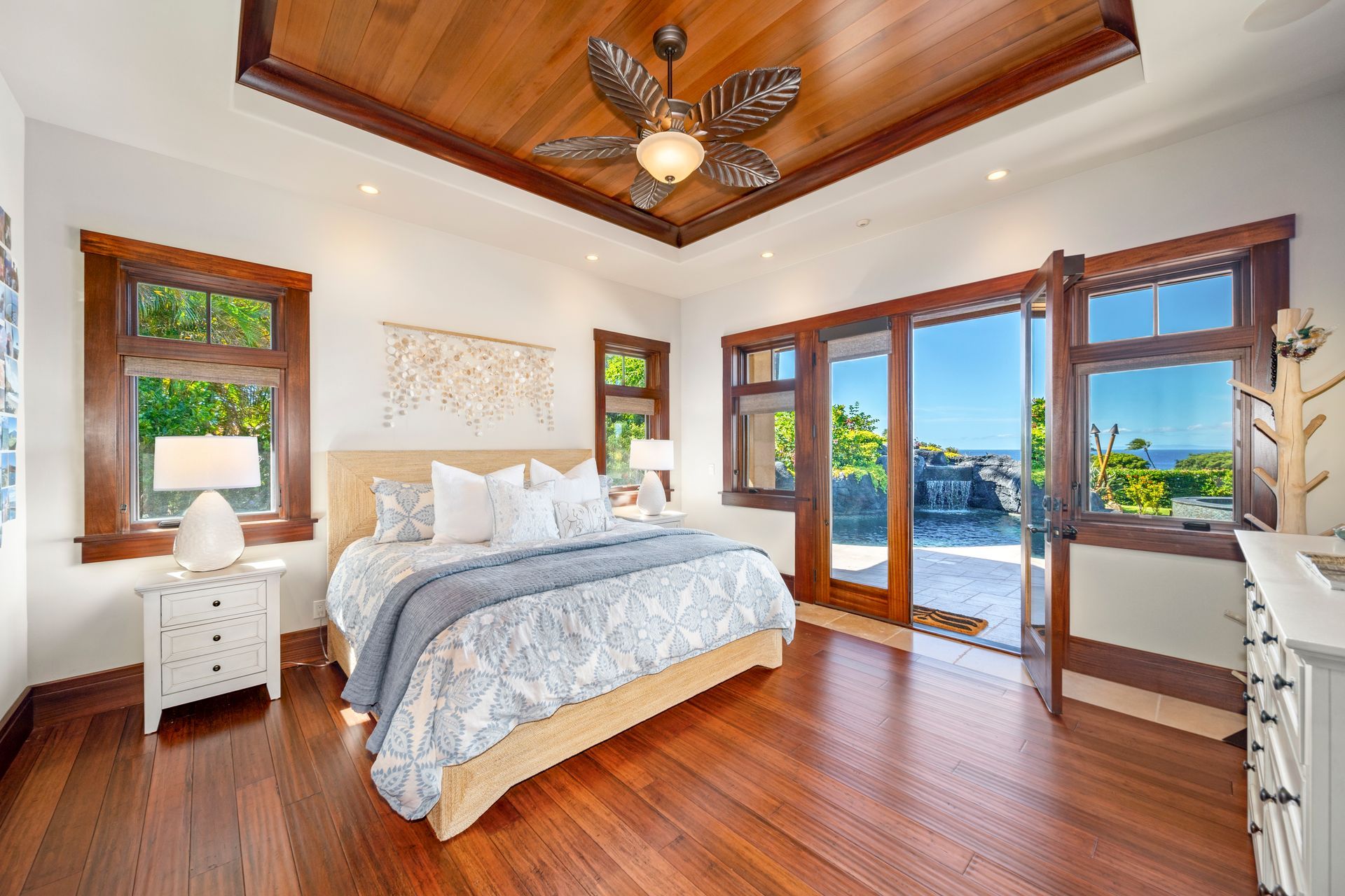 A bedroom with a large bed and a ceiling fan.