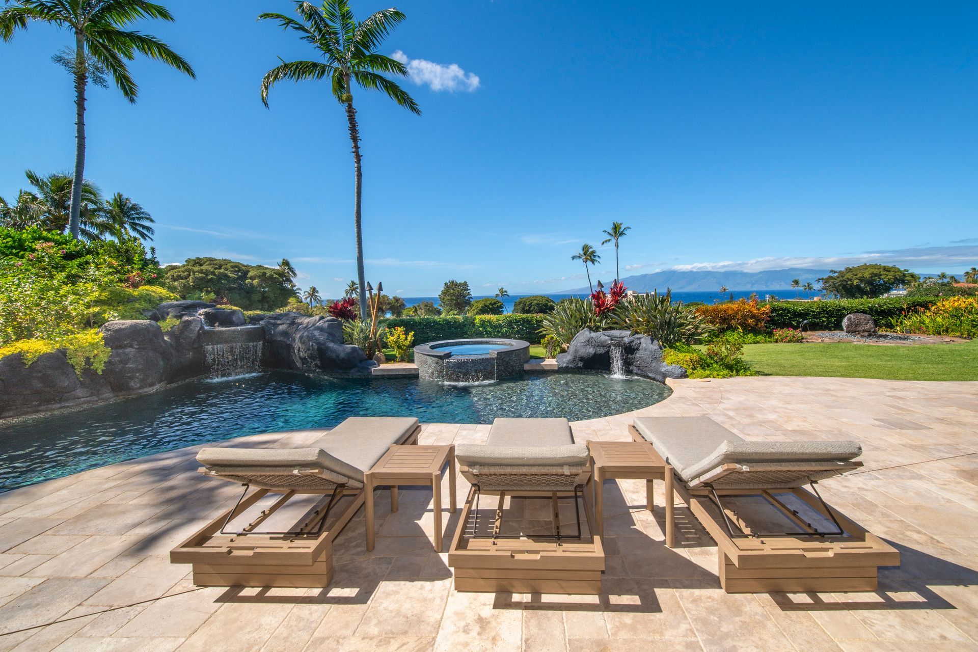 A patio with chairs and tables next to a swimming pool.
