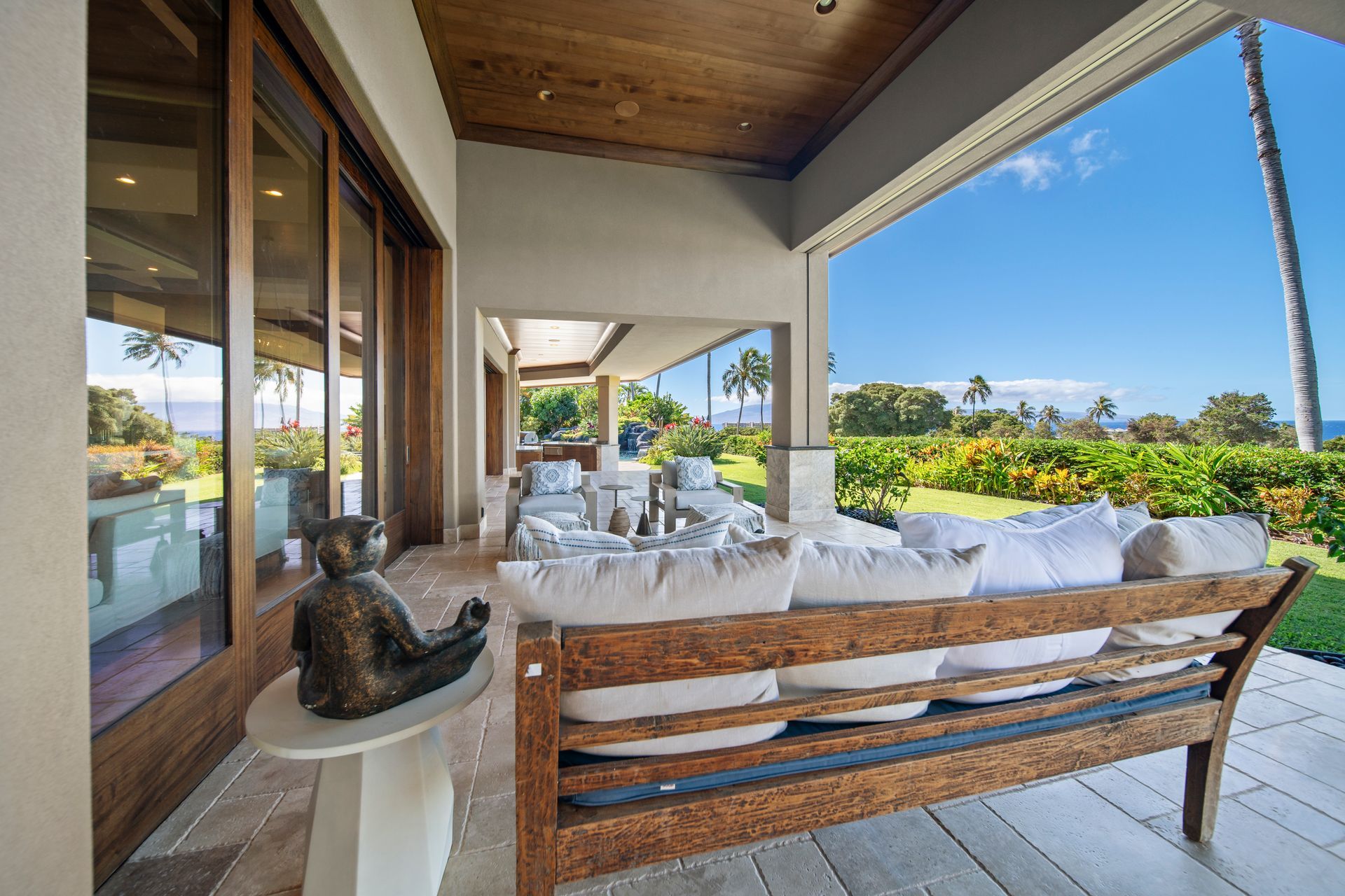 A porch with a wooden bench and a statue