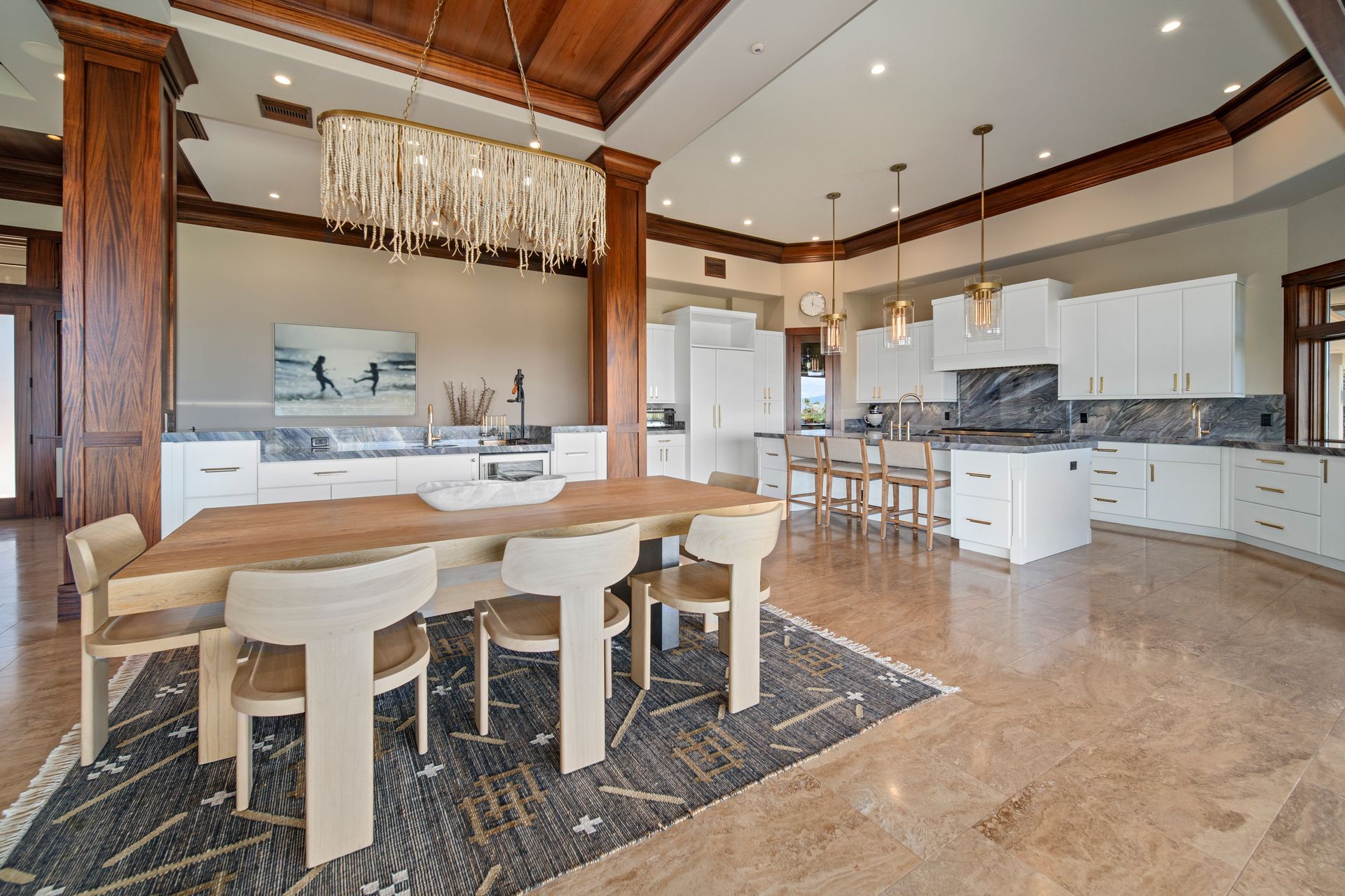 A large dining room with a wooden table and chairs and a chandelier hanging from the ceiling.
