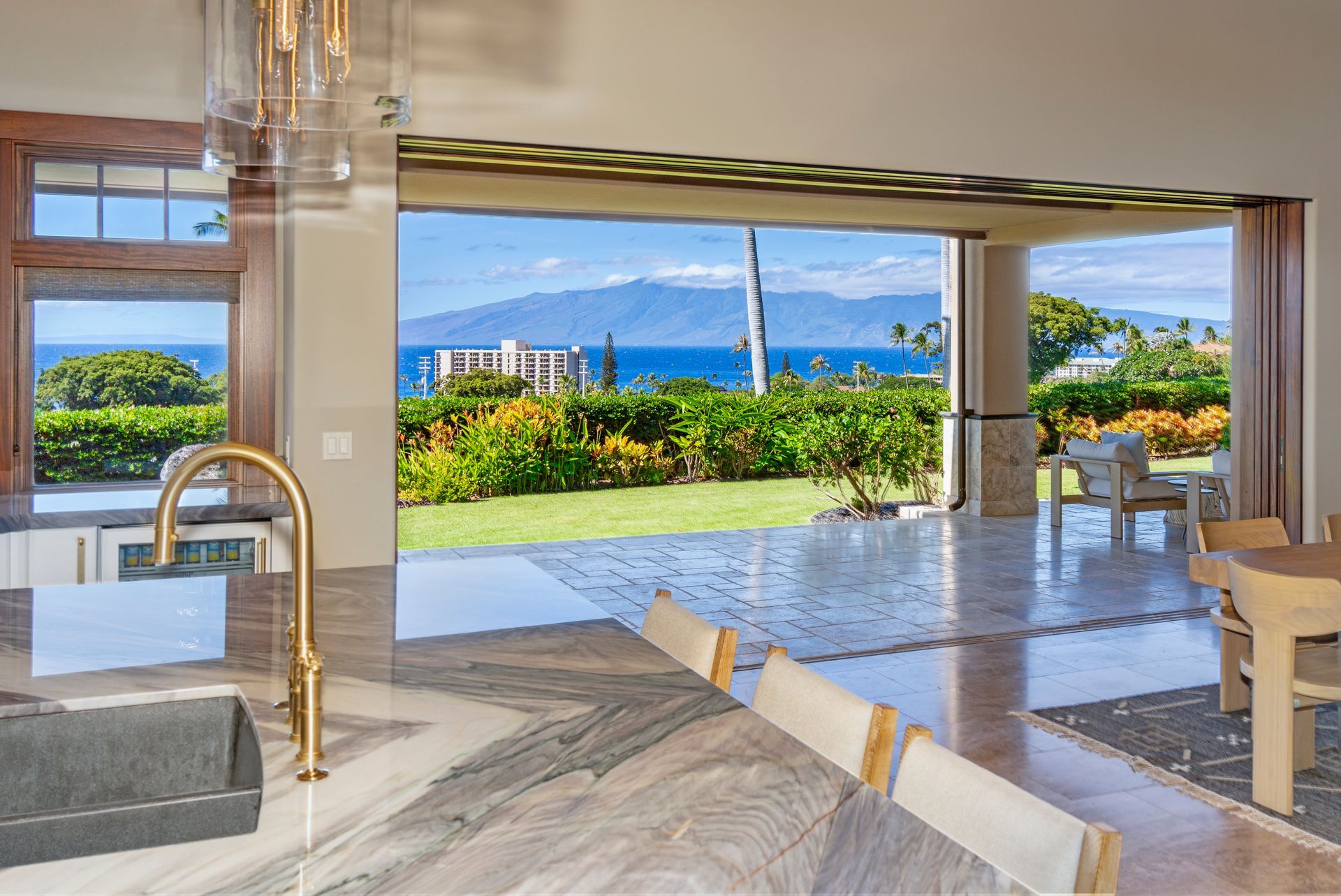 A kitchen and dining room with a view of the ocean and mountains.