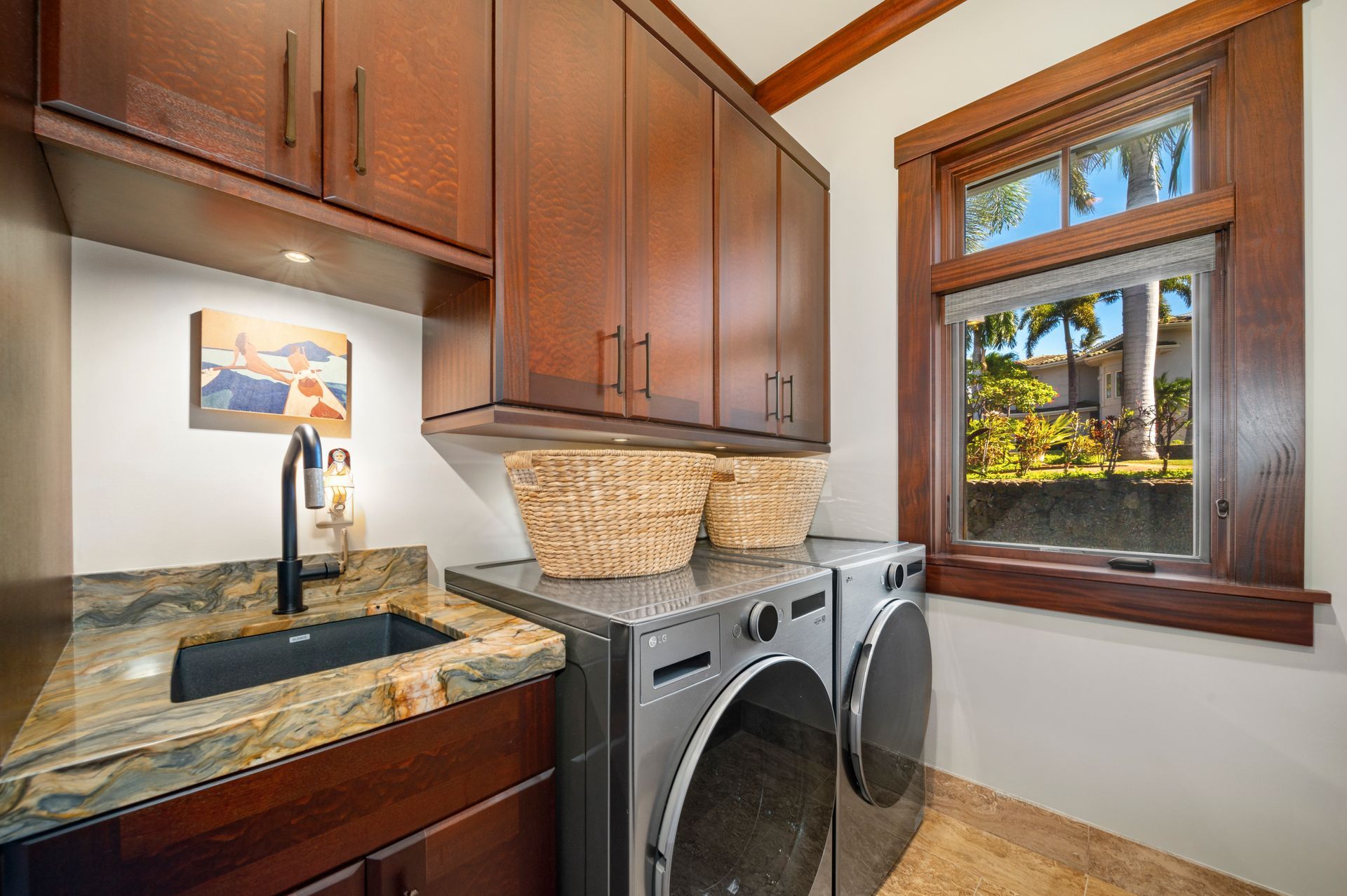 A laundry room with a washer and dryer , sink , and window.