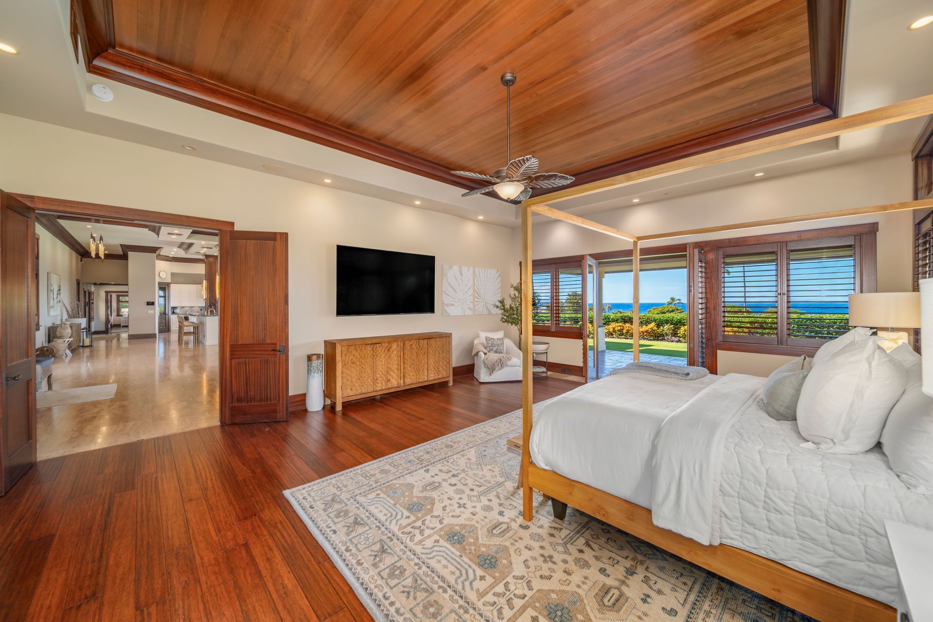 A large bedroom with a canopy bed and a flat screen tv.