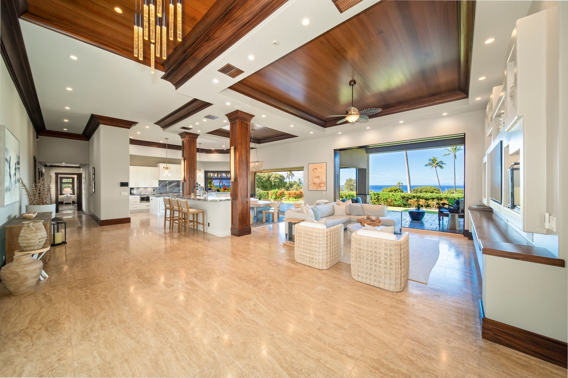 A large living room with a wooden ceiling and a view of the ocean.