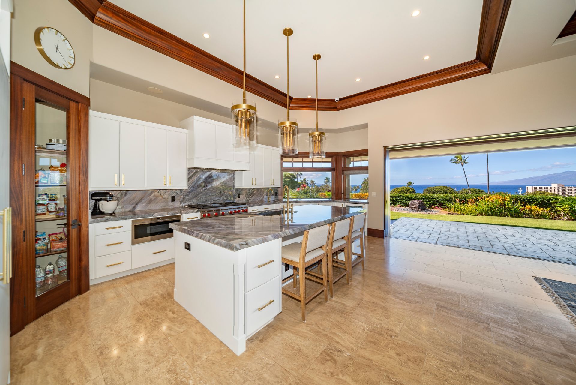 A kitchen with a large island and a clock on the wall.