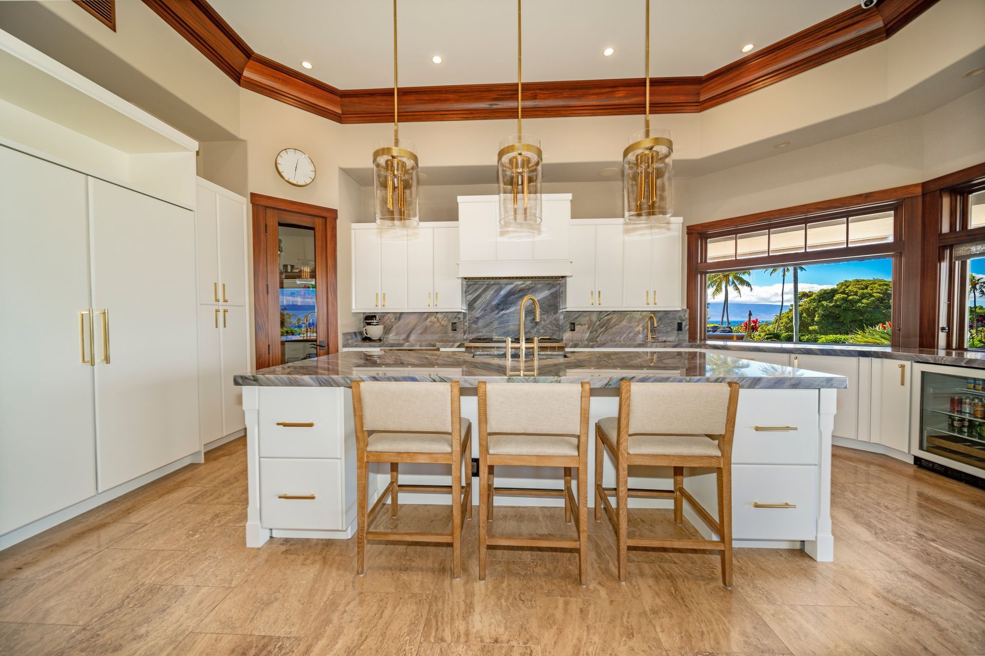A kitchen with a large island and chairs in it.