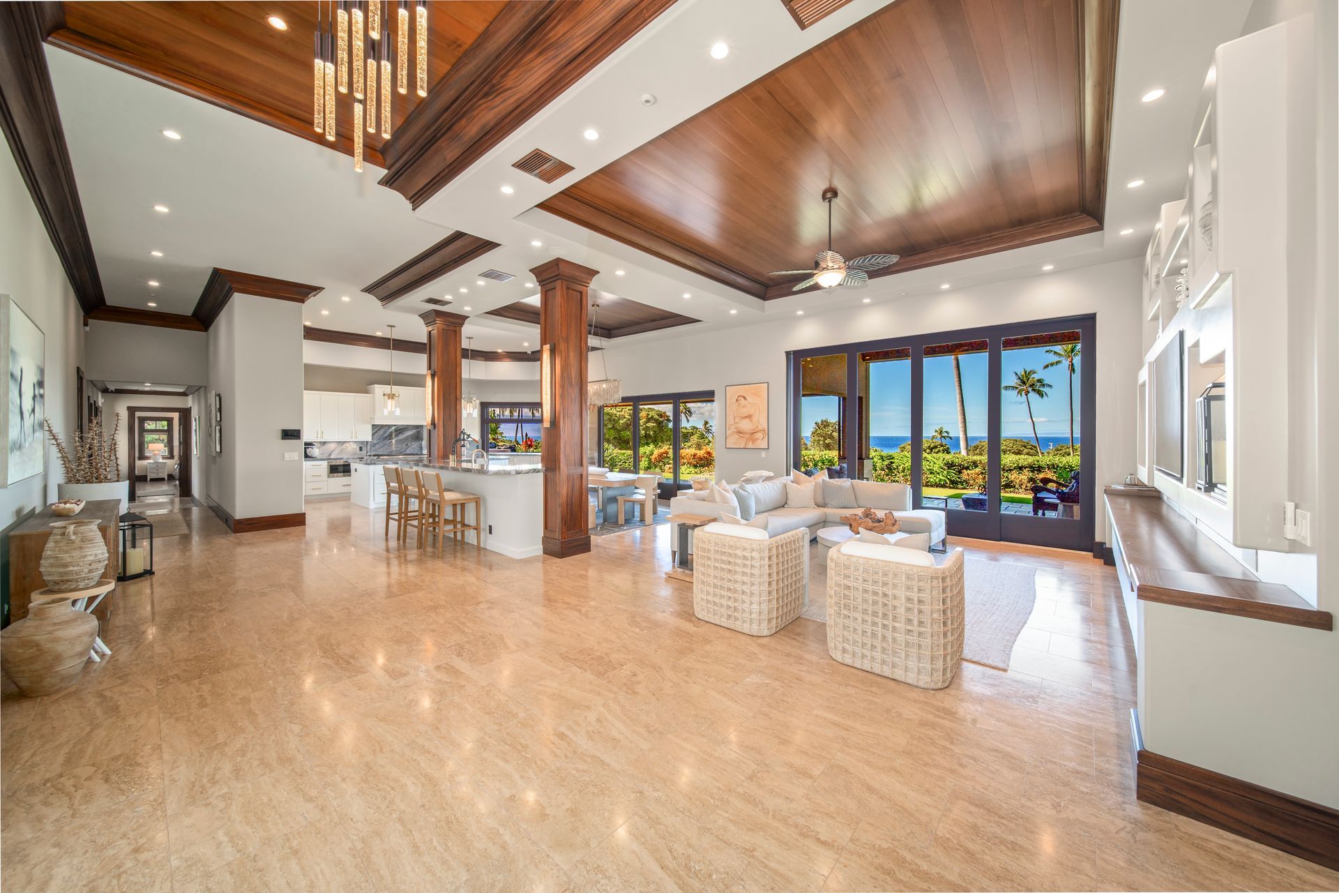 A large living room with a lot of windows and a ceiling fan.