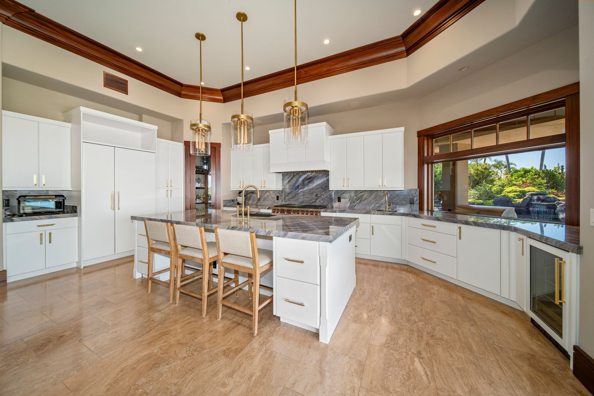 A large kitchen with white cabinets , granite counter tops , and a large island.