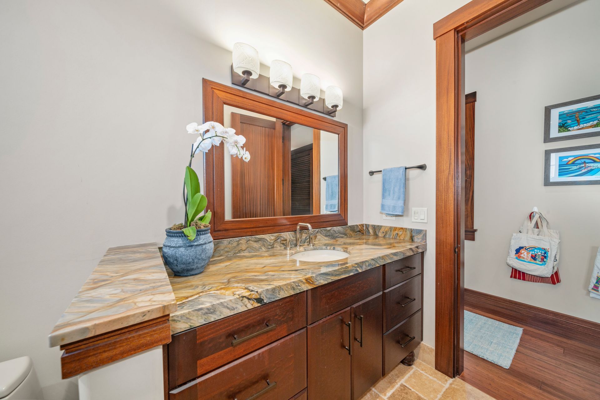 A bathroom with a sink , mirror and toilet.