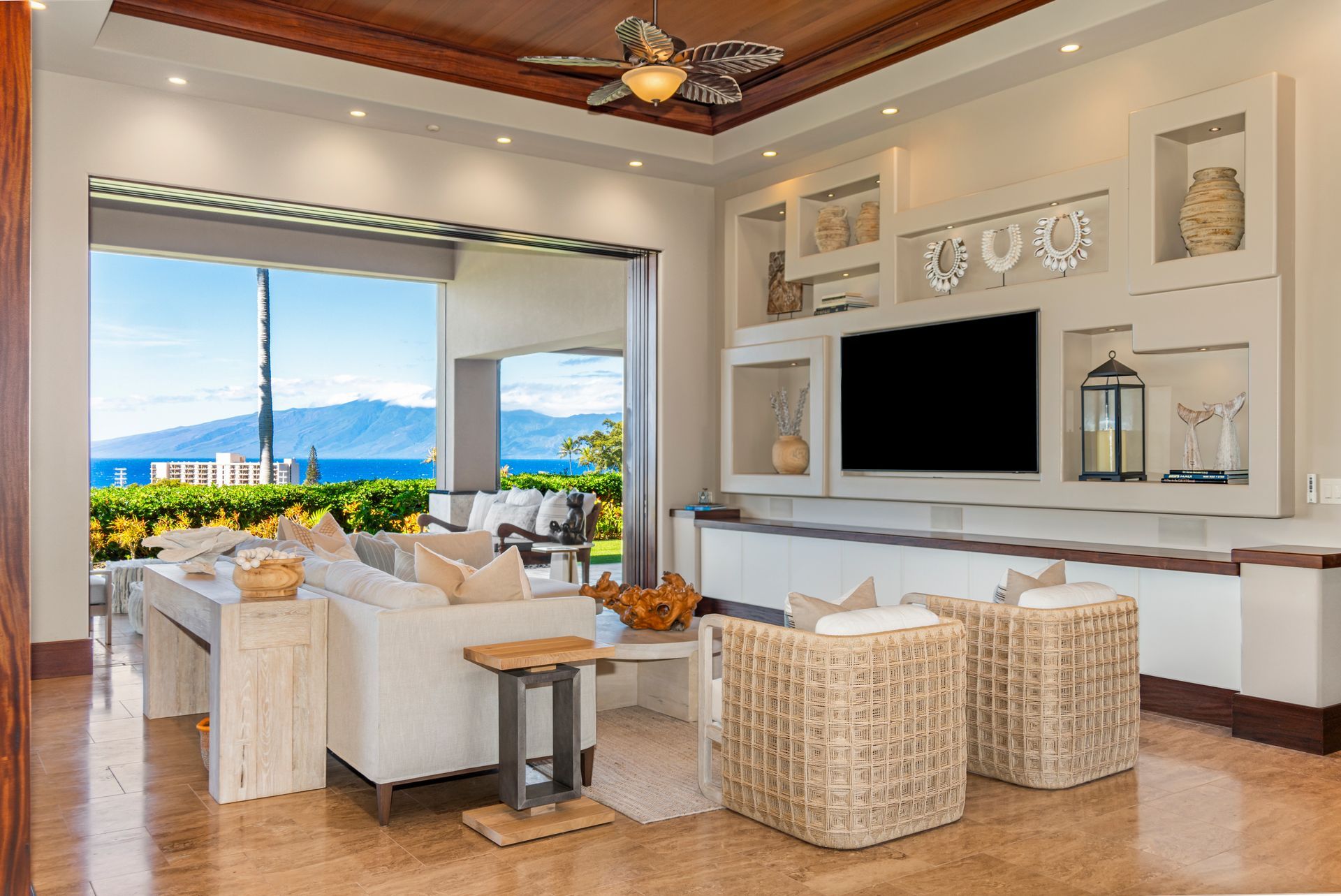 A living room with a couch , chairs , and a flat screen tv.
