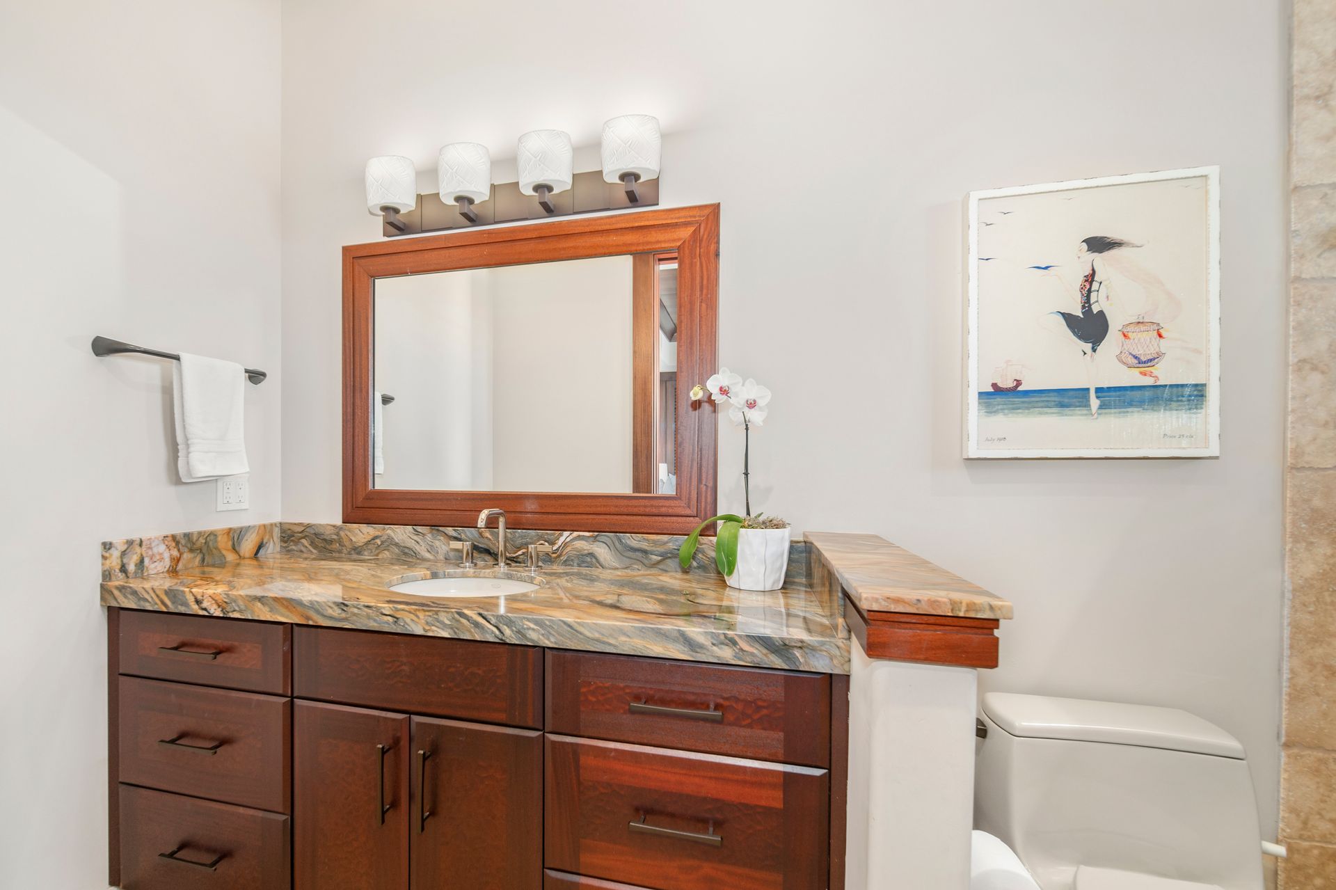 A bathroom with a sink , mirror and toilet.