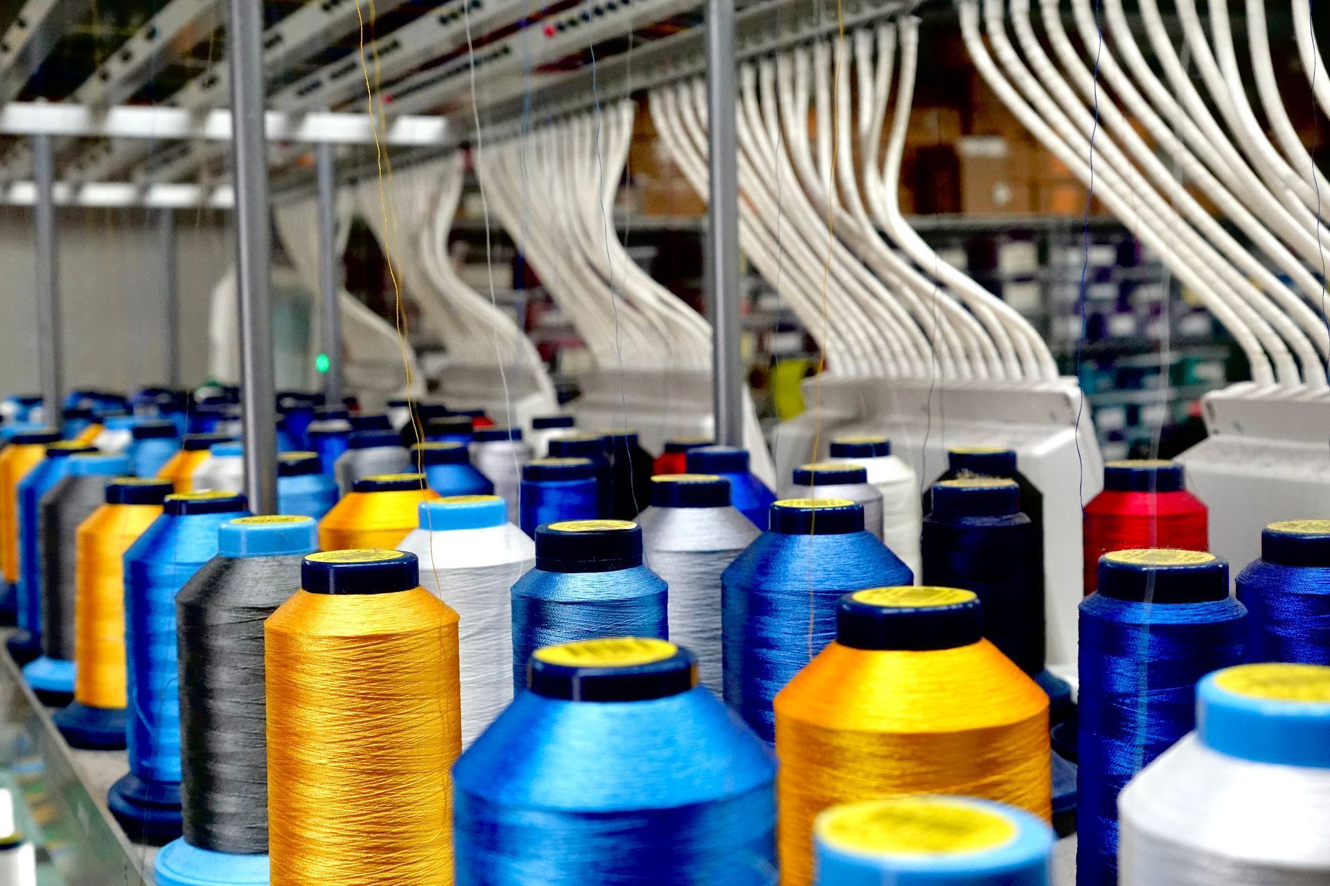 A bunch of spools of thread are sitting on a table in a factory.