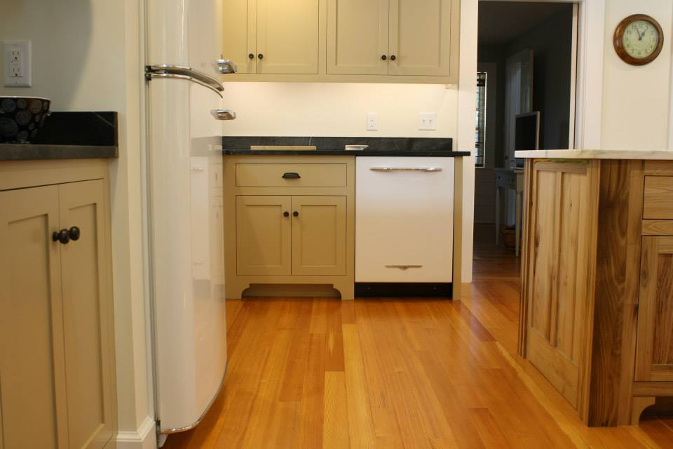 Kitchen with light wood cabinets, white appliances, and a hardwood floor.
