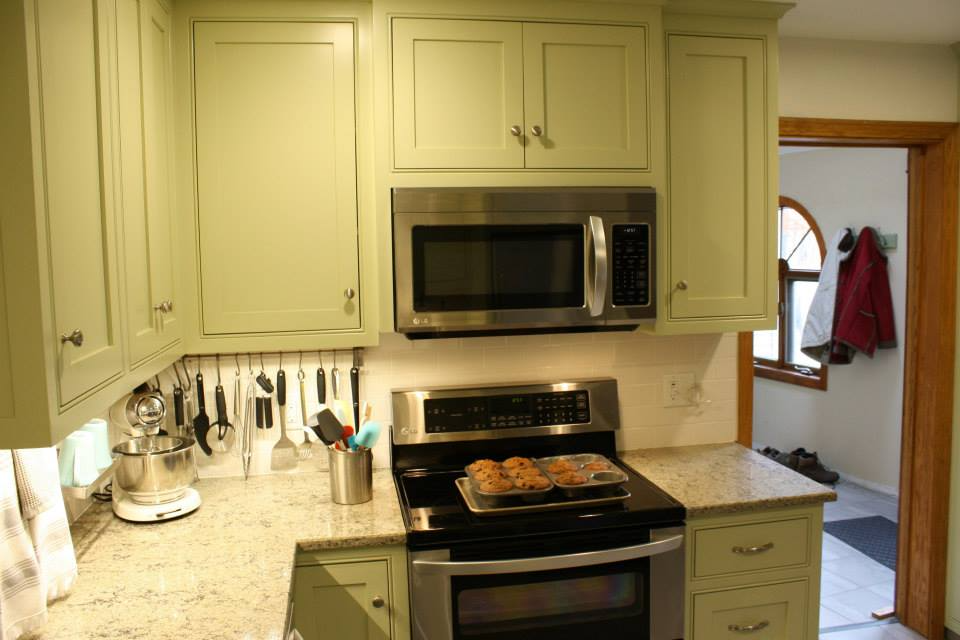 Kitchen with light green cabinets, stainless steel appliances, and a granite countertop.