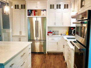 White kitchen with stainless steel appliances, cabinets, and island.