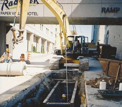 An excavator is digging a hole in front of a building that says ramp