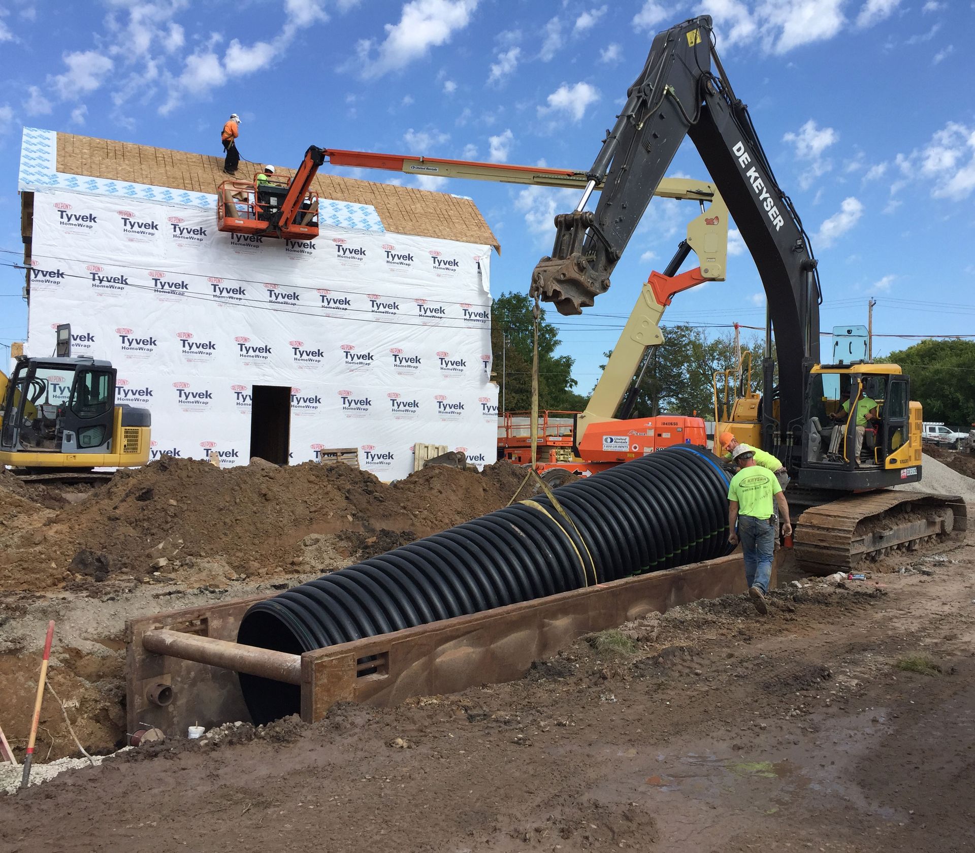 A construction site with a bobcat excavator in the foreground