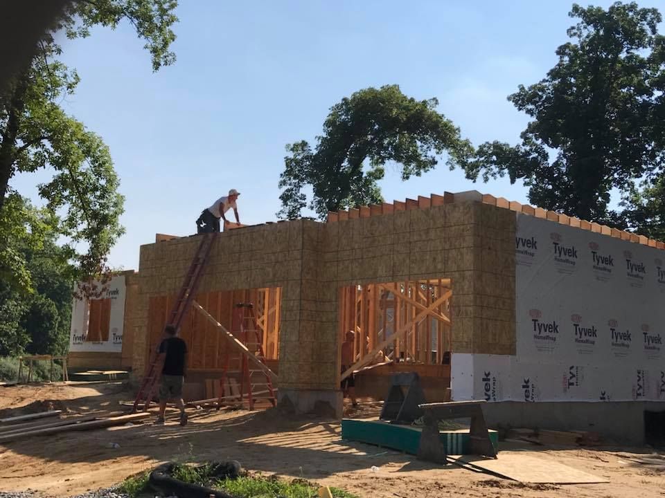 a man is working on the roof of a house under construction