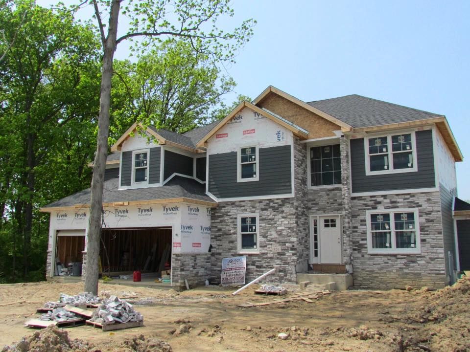 a large house is being built in the middle of a dirt field .