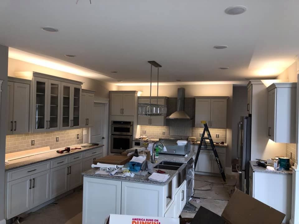 a kitchen is being remodeled with white cabinets and a large island .