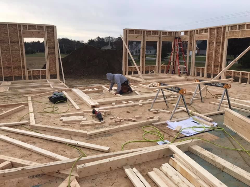 a man is working on a wooden frame of a house .