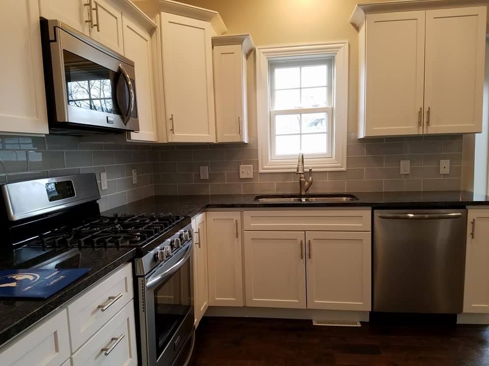 a kitchen with white cabinets and stainless steel appliances