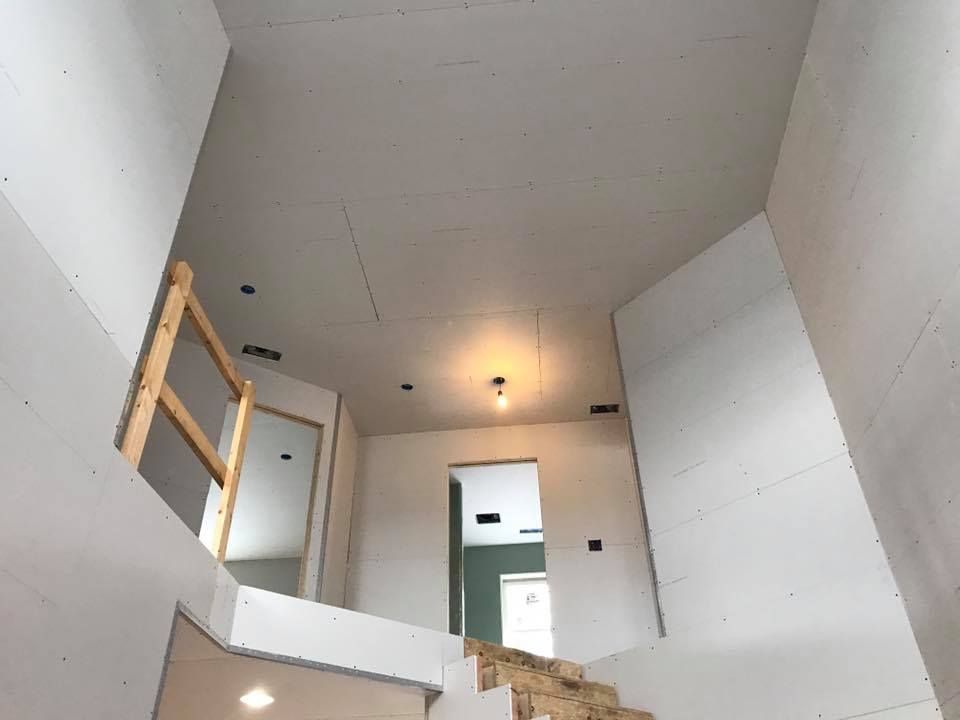 a staircase is being built in a room with a wooden railing .