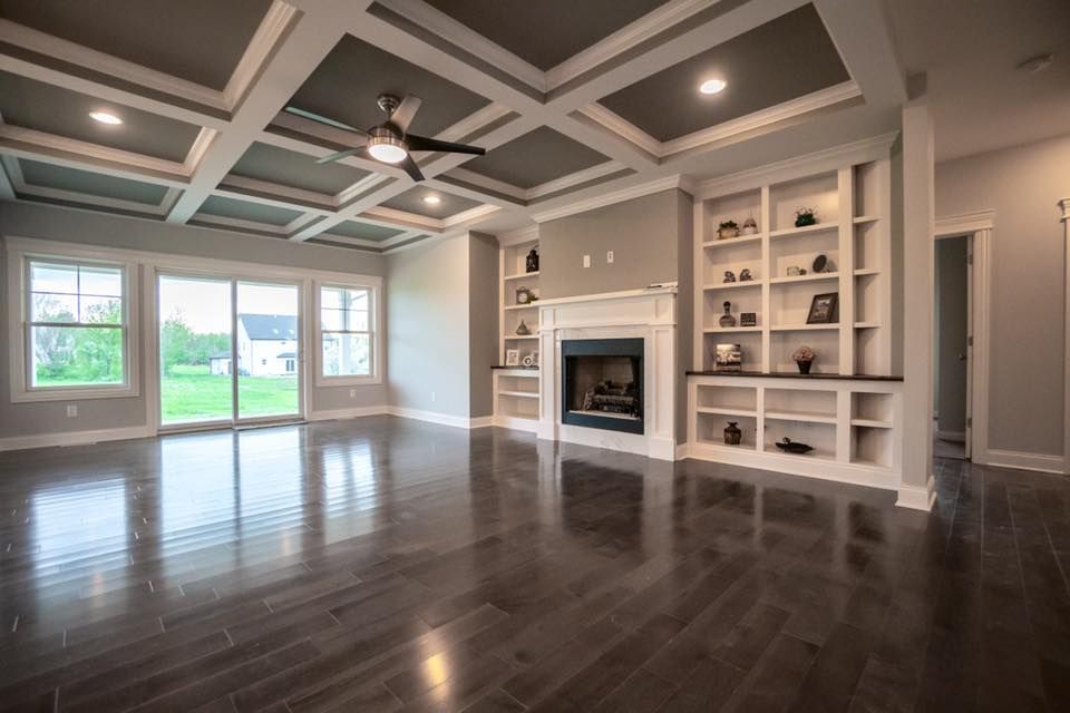 an empty living room with hardwood floors and a fireplace .