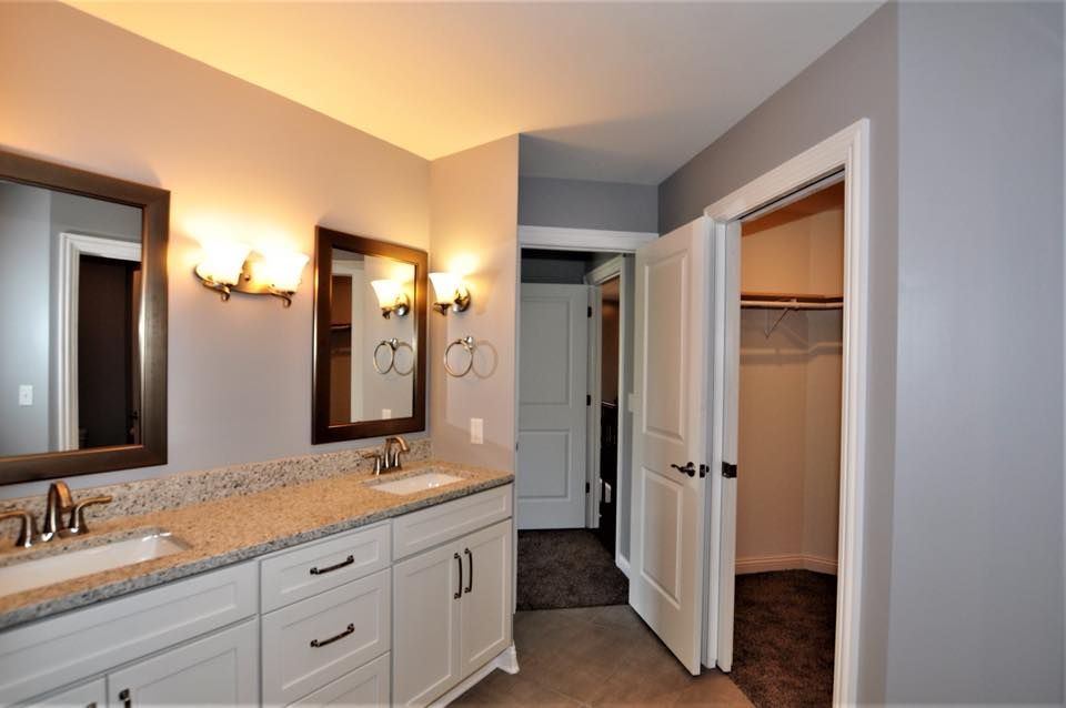 a bathroom with two sinks and two mirrors