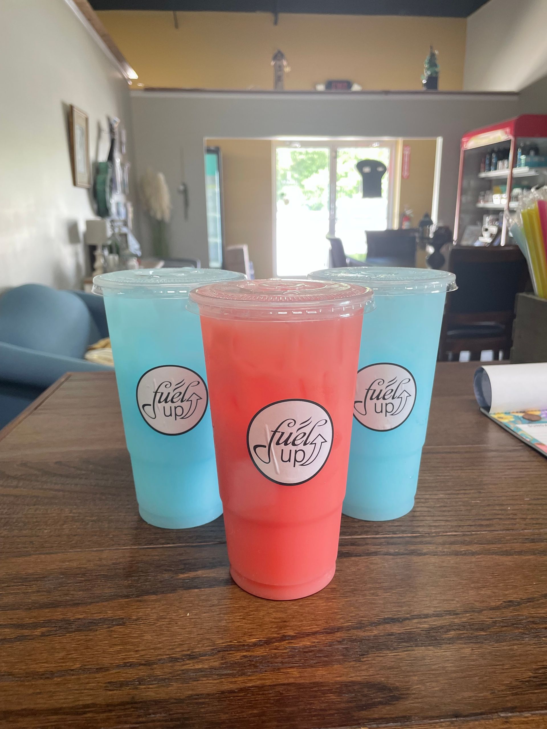 Three cups of drinks are sitting on a wooden table.