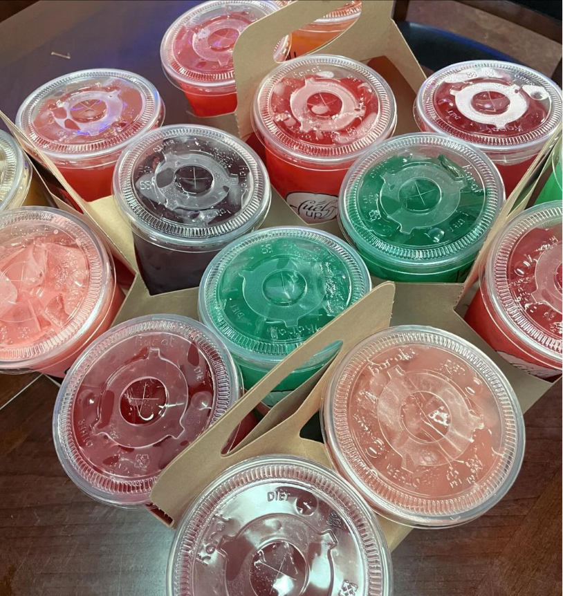 A bunch of cups of different colored liquids on a table