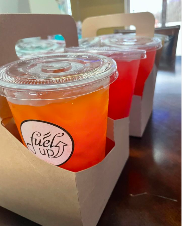 Four cups of fuel up drinks are in a cardboard box