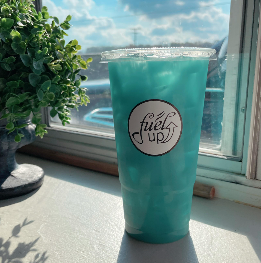 A cup of blue liquid with the word fuels up on it