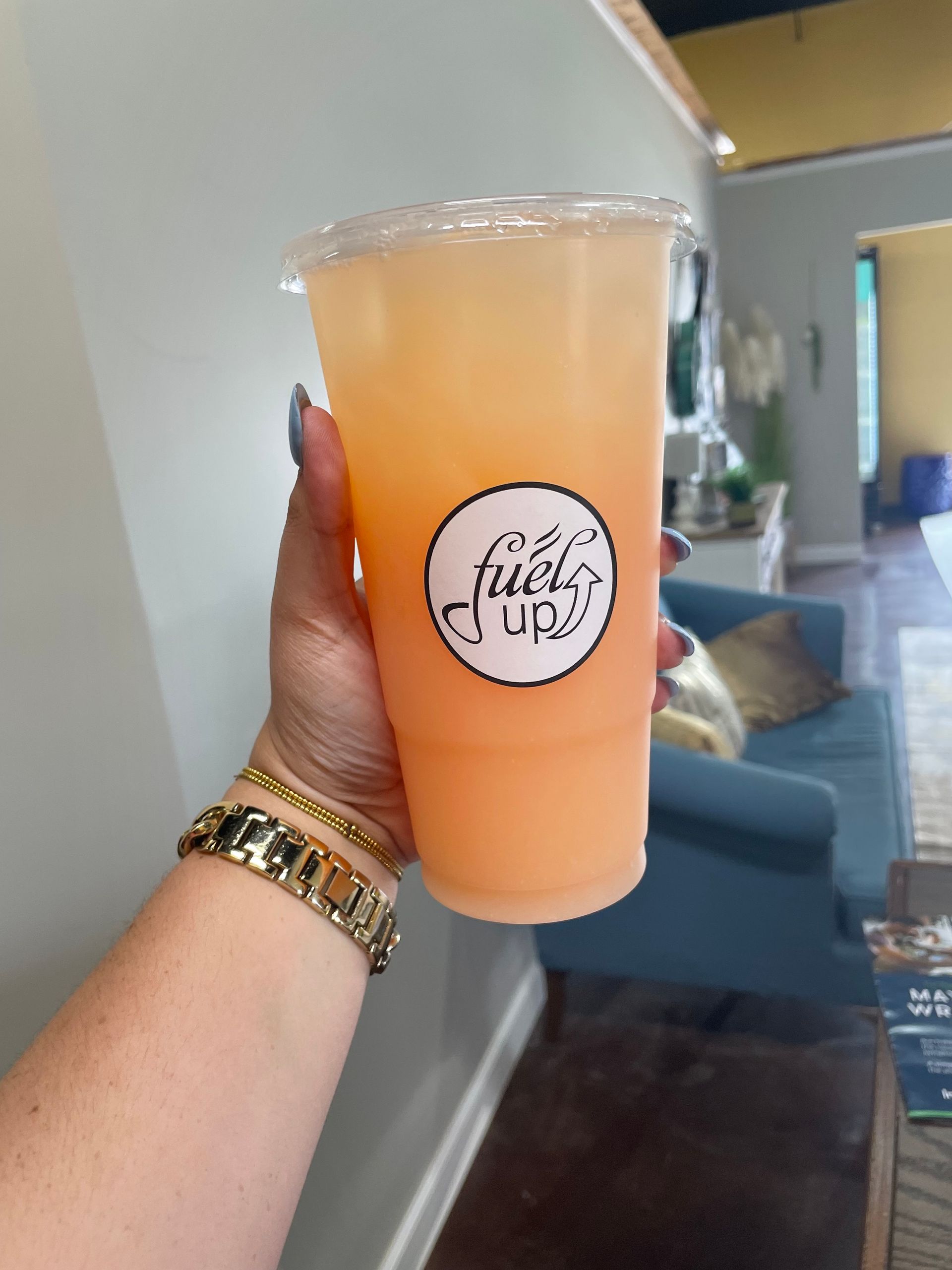 A person is holding a cup of juice that says fully up