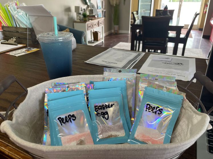 A basket filled with bags of easter eggs is on a table.