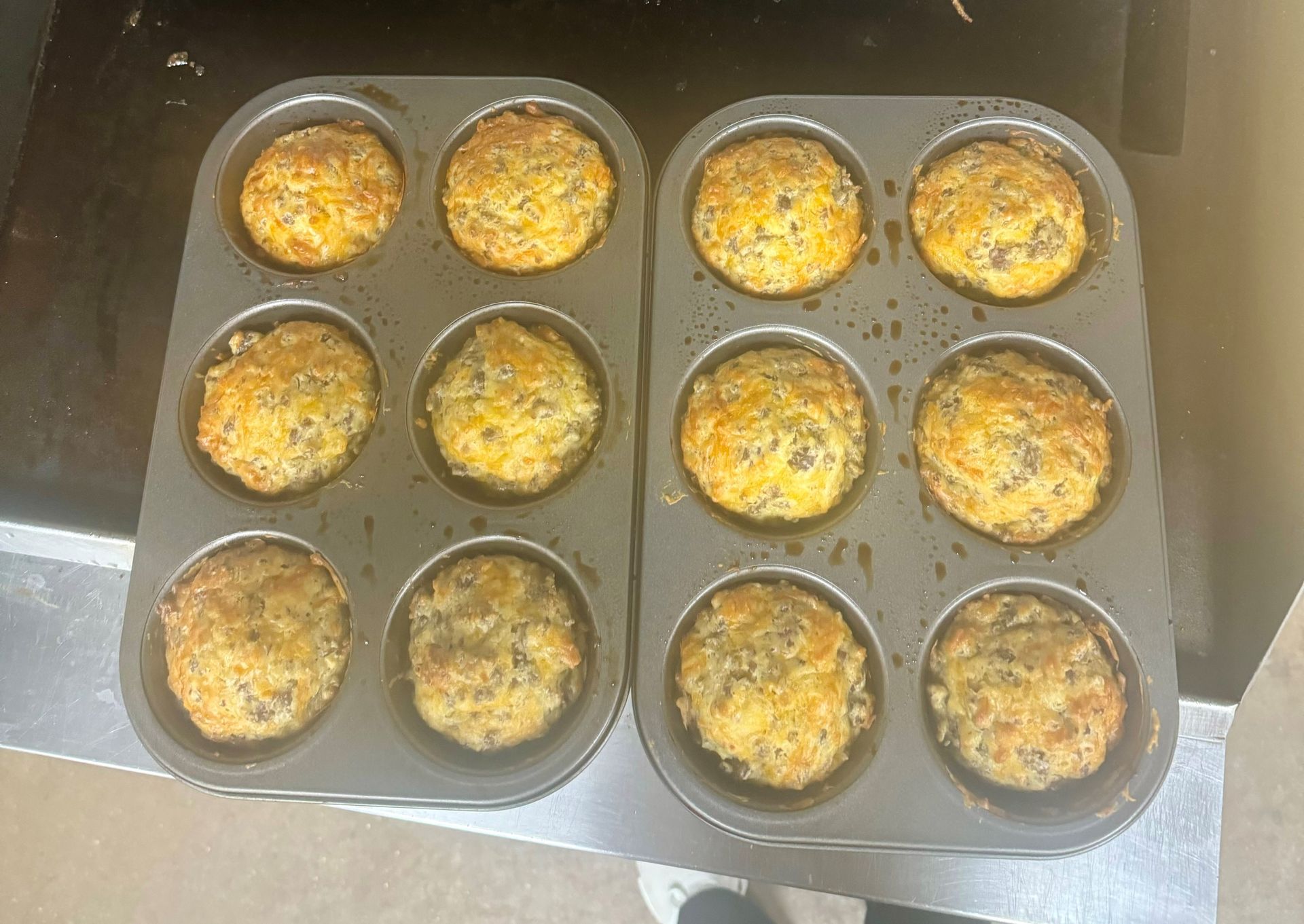 Two muffin pans filled with muffins are sitting on a counter.