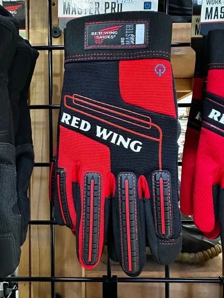 Red and black Red Wing work glove hanging on a store display rack