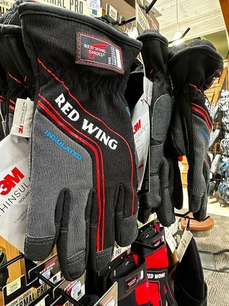Red Wing work gloves hanging on a store display rack