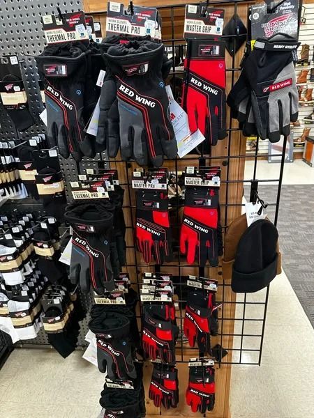 Display of black and red sports gloves hanging on a retail rack in a store.