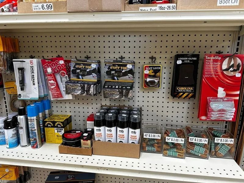 Shelf of assorted packaged hardware and small tools on a store aisle, with price tags above.