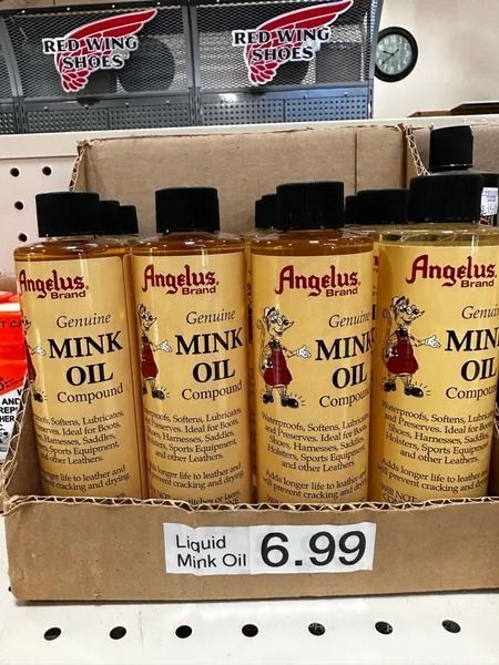 Shelf of Angelus liquid mink oil bottles with a $6.99 price tag in a store.