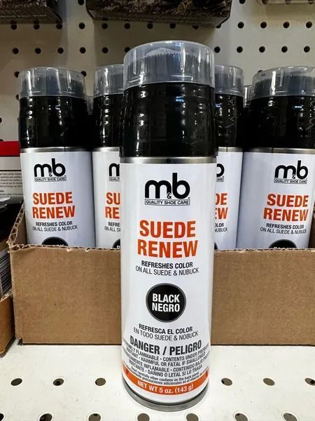 MB Suede Renew cleaner bottles on a store shelf, one centered in front of cardboard packaging.