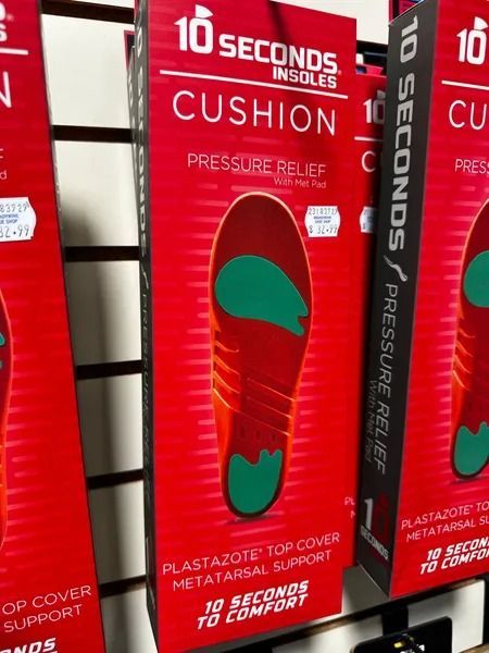 Red athletic insoles in red-and-black packaging on a store shelf, labeled “10 seconds” and “CUSHION.”