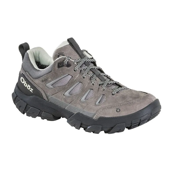 Gray hiking shoe with black sole and laces on a white background