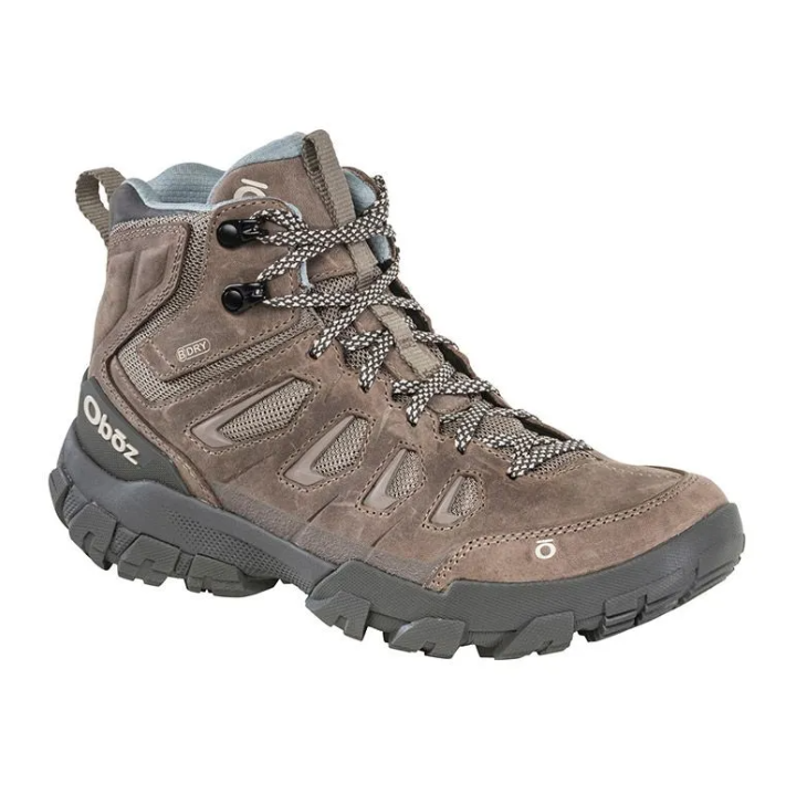 Brown and black hiking boot with rugged sole and laces on a white background