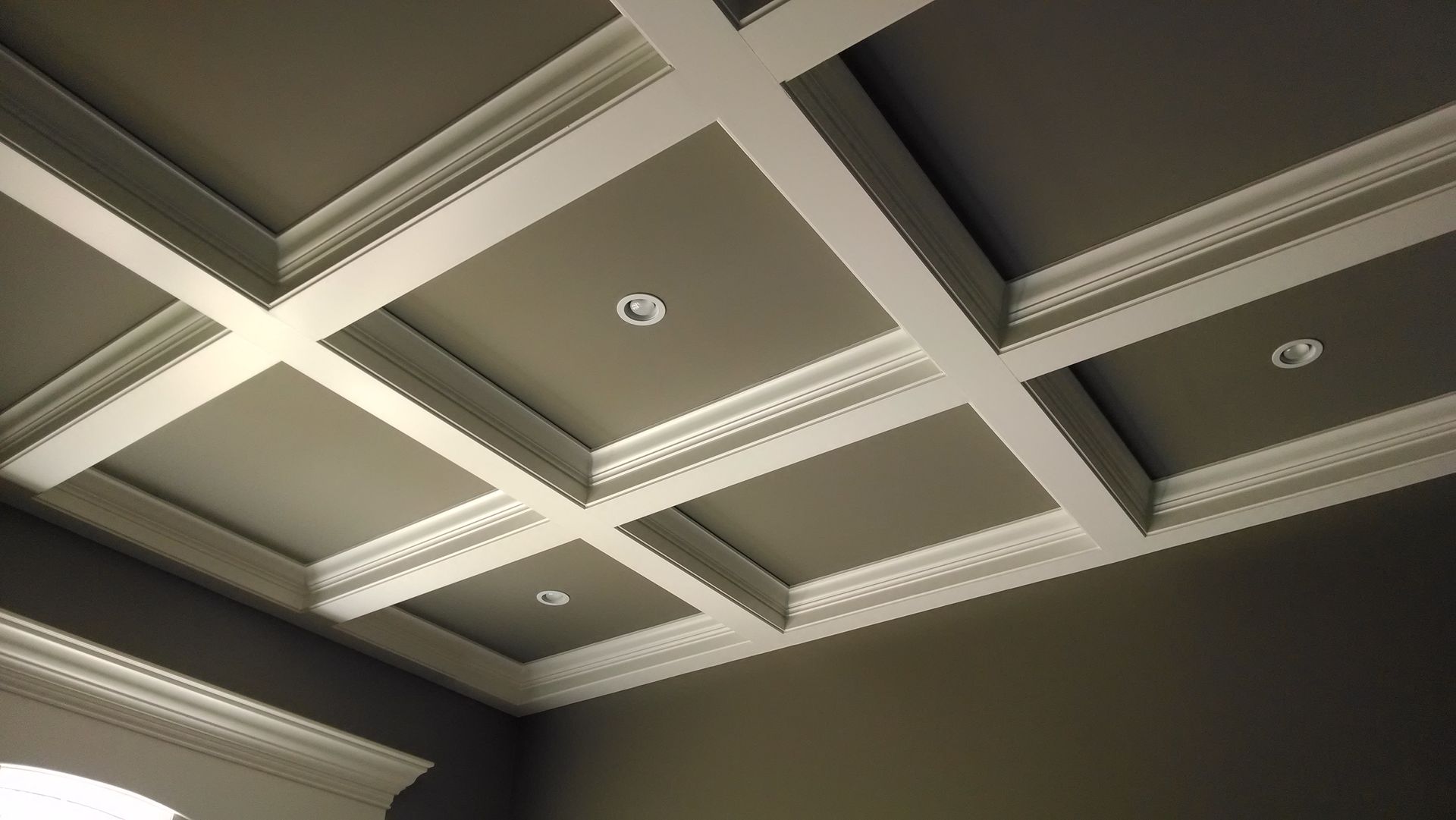A coffered ceiling with white molding in a room