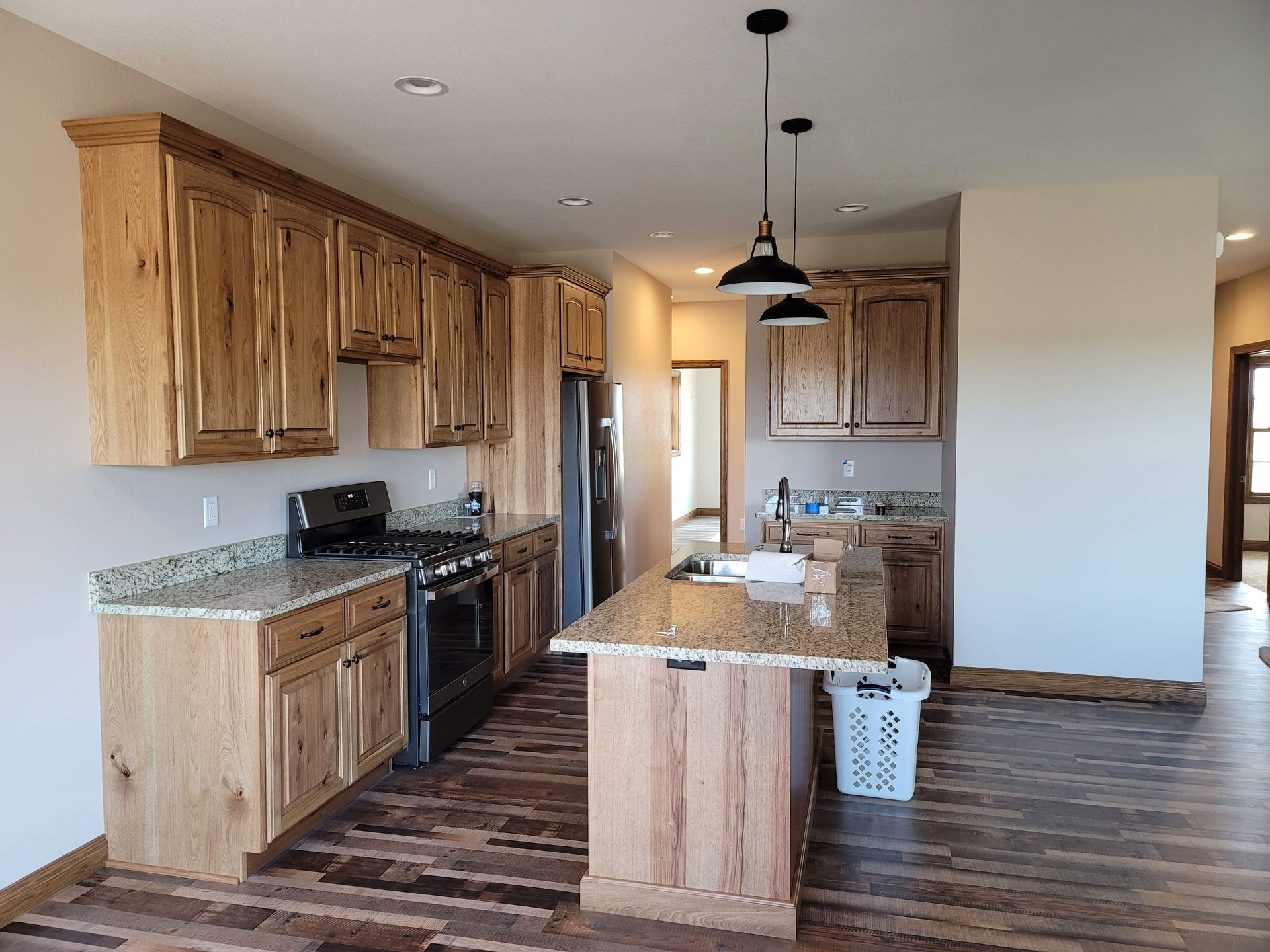 A kitchen with wooden cabinets , granite counter tops , stainless steel appliances , and a large island.